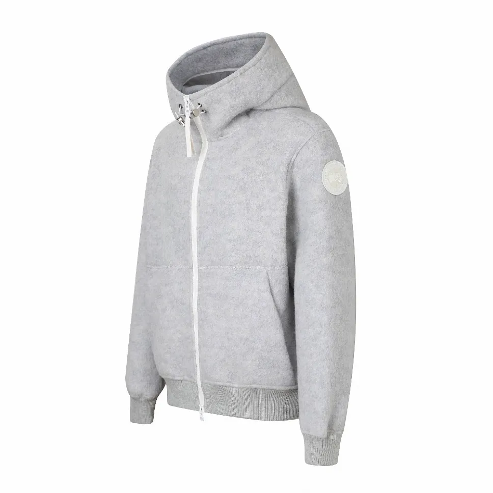 P780 Canada Goose Wool Fleece Hooded Jacket (Light Gray) The fabric is made of wool fleece fabric, which is mainly made of wool and mixed with a very small amount of spandex and polyester fiber. Wool is a core natural ingredient that provides unparalleled temperature regulation, antibacterial and anti-odor properties and a skin-friendly feel. The feeding of a small amount of spandex gives the fabric a certain degree of four-way elasticity, making it non-restrictive during daily activities. As the basis of fleece's structure, polyester fiber enhances the fabric's durability, wrinkle resistance and quick-drying properties. It contributes to the loft of the fleece and provides functions such as trapping air. The sleeves and hem are closed with 2×2 ribbing. Its strong elasticity can closely fit wrists and waists of different thicknesses, forming an effective 'seal' to prevent cold wind from blowing back. It can still maintain its original shape after repeated stretching and use, and is not easy to loose and deform. And the ribbed cuffs can convey a sense of design and enhance the visual beauty. The combination of hood design and elastic buckle improves warmth and windproof performance when worn. Size:S-M-L-XL